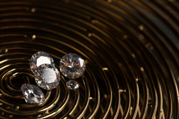 Beautiful shiny gemstones on golden tray in dark, closeup. Space for text