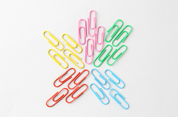 Colorful paper clips on light background, flat lay