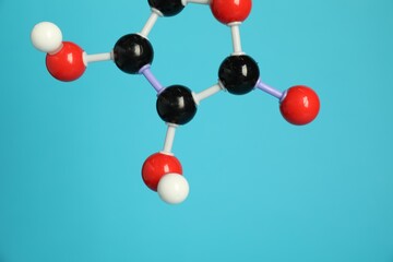 Molecule of vitamin C on light blue background, closeup. Chemical model