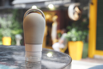 Squeeze bottle on a table in a vibrant outdoor cafe setting