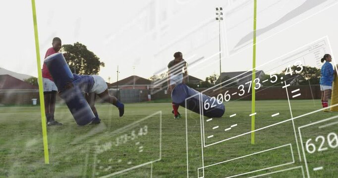 Football players practicing with tackling dummies on field, data overlay animation