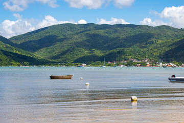 barco de pesca na praia e montanhas e o mar tranquilo em Santa Catarina Governador Celso Ramos Praia da Camboa e Praia Fazenda d'Armação  Brasil