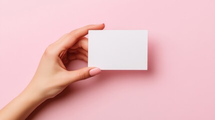 Obraz premium Woman's hand holding blank card, pink background
