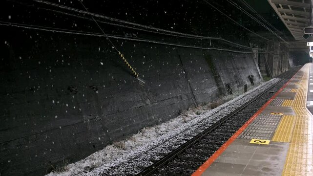雪の降る誰もいない夜の駅のホーム　線路・冬・寒い