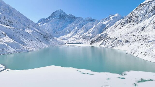 Aerial view of a frozen lake between mountains and in front of the highest mountain in New Zealand, Mount Cook.