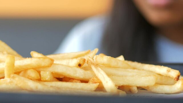 child hand pick Crispy french fries served at a local eatery