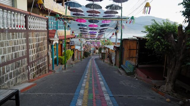 A colorful street in San Juan La Laguna, Guatemala, La Calle de las Sombrillas, umbrellas overhead sway in wind