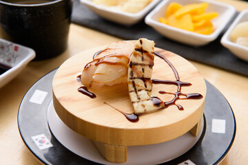 Grilled mushroom scallop sushi on wooden plate
