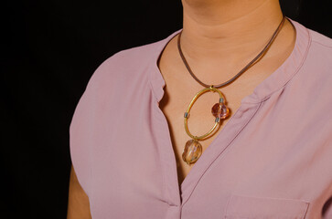 Primer plano del cuello de una mujer adornado con un delicado collar con colgante de diamante,...