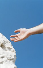 Reaching for the Sky: A hand, extended against a backdrop of the sky, hints at a longing for connection or reaching for a goal or aspiration.  The composition conveys themes of aspiration.
