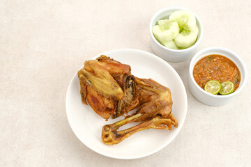 Ayam Goreng or Fried Chicken with sambal and cucumber, Indonesian food
