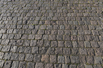 Stone road background texture. Textured background of cobblestone road. Road from brick background. Paving stone and paved road. Sidewalk background.