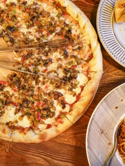 Italian pizza with vegetables and parmesan on a wooden tray on the table