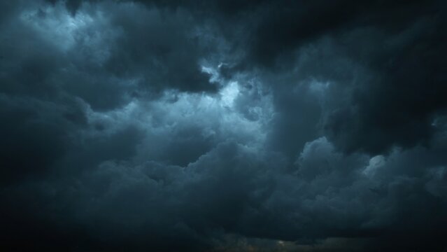 Ominous and dramatic dark stormy sky with billowing clouds and a soft glow creating an eerie atmosphere.