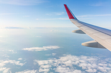 Obraz premium View from the airplane window at a beautiful cloudy sky and the airplane wing
