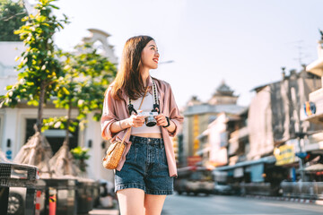 Happy adult asian woman traveler using digital camera travel in southeast asia at outdoors on day