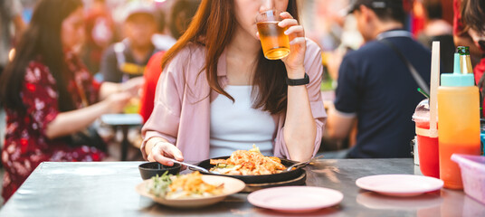 Young adult traveler woman enjoy eating street food spicy thai tasty menu travel at chinatown...