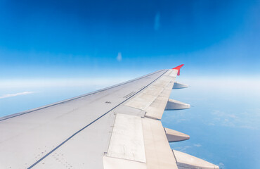 View from the airplane window at a beautiful cloudy sky and the airplane wing