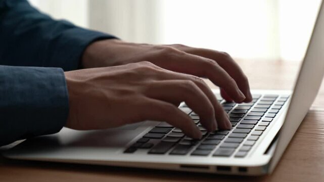 Businessman hand work on capable laptop computer at office table close up shot and selective focus at middle section of laptop computer keyboard while typing and working