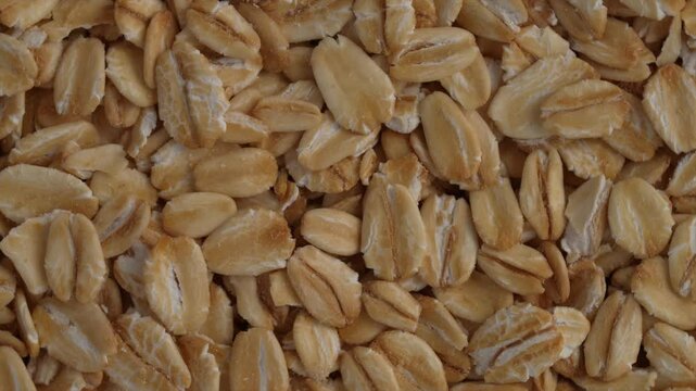 Closeup, top view of a rotating pile of raw rolled oats flakes. Healthy Diet concept