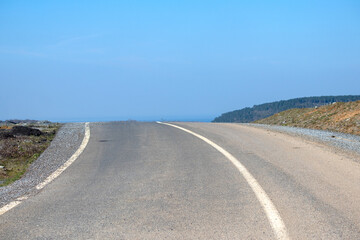 Empty asphalt road and blue sky in countryside. Travel, road trip idea concept. Copy space, blank. 