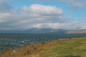 landscape with lake, green field and clouds