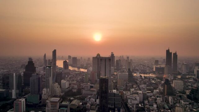 Sunset at Bangkok high aerial view of the Chao Phraya River at Si Lom districts at sunset. A large asian capital city with skyscrapers and millions of inhabitants. Beautiful Cinematic 4k footage 2025