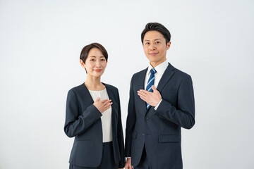 胸に手を当てるビジネスマン二人