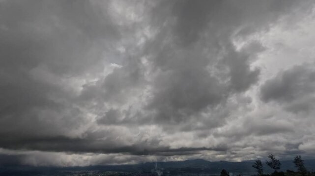 Timelapse of black clouds and rain covering the horizon seen from the mountains. Ecology and environmental concept. Related to climate and weather. 4K footage