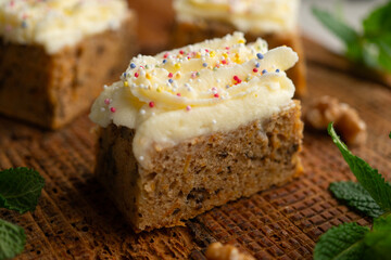 Small slices of carrot cake with a cream cheese frosting and caramel balls for decoration.