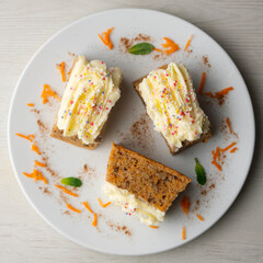 Small slices of carrot cake with a cream cheese frosting and caramel balls for decoration.