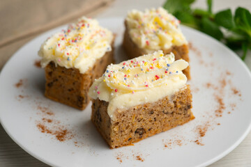Small slices of carrot cake with a cream cheese frosting and caramel balls for decoration.