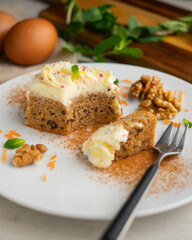 Small slices of carrot cake with a cream cheese frosting and caramel balls for decoration.