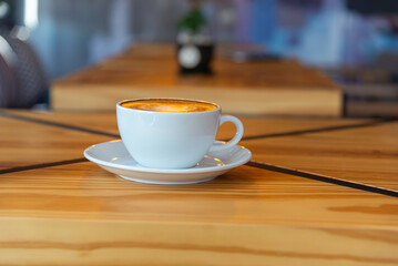 coffee latte art on wood table in cafe nature light