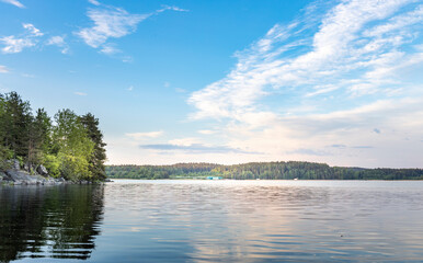 A calm lake with a few trees in the background