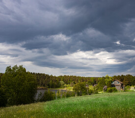 A cloudy sky with a house in the distance