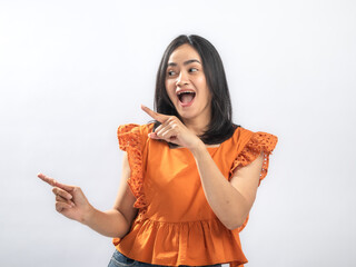 Joyful Southeast Asian woman with straight black hair wearing orange ruffled blouse and jeans,...