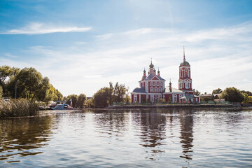 Naklejka premium The Golden Ring of Russia, the city of Pereslavl-Zalessky. The Church of the Forty Sevastian Martyrs is reflected in the afternoon in Pleshcheyev Lake.