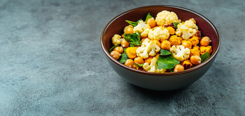 Summer salad bowls concept. Bowl of mixed vegetables and chickpeas on a textured surface.