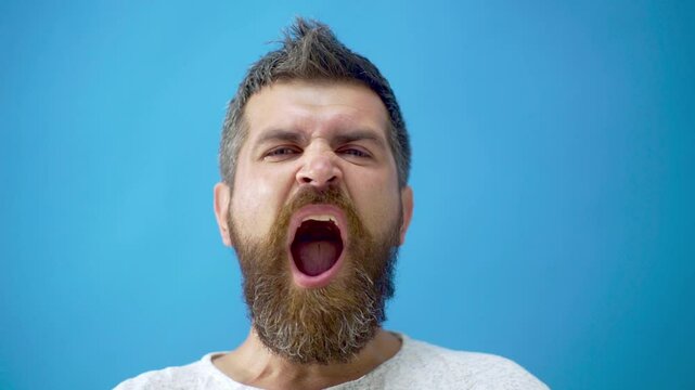 Man expressing his feelings and facial expressions. Man Facial Emotions. Male Character, Furrow Brows, Angry, Shocked Expression. Studio close up portrait of bearded man confused facial expression.
