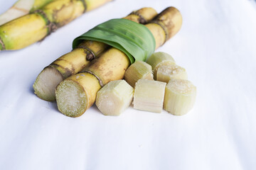 A bunch of sugar cane is cut into small pieces