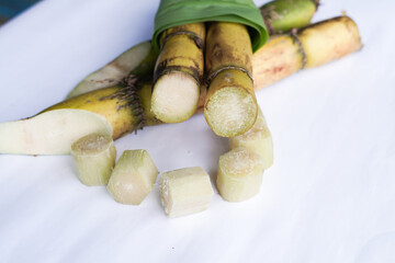 A bunch of sugar cane is cut into small pieces