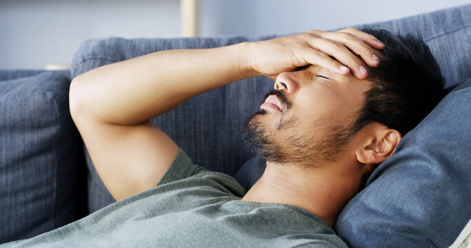 Tired, man and sleeping with migraine at house for stress, dream and nap for burnout. Fatigue, male person and headache with brain fog for exhaustion, overworked and anxiety crisis for health issues