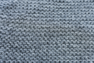 Close up of grey knitted fabric texture. Woolen background.