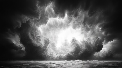 Fototapeta premium Dramatic monochrome seascape with a turbulent sky, showcasing a bright opening amidst dark clouds above a choppy sea.
