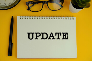 LATEST UPDATE text with notepad on wooden background. Business and copy space concept