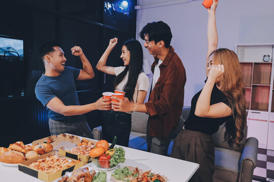 Happy young friends group having lunch at home. Asia family party eating pizza food and laughing enjoying meal while sitting at dining table together at house. Celebration holiday and togetherness.