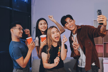 Happy young friends group having lunch at home. Asia family party eating pizza food and laughing enjoying meal while sitting at dining table together at house. Celebration holiday and togetherness.