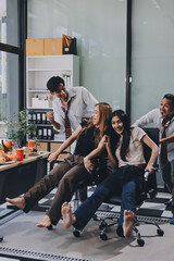 Asian office colleagues and friends enjoy a daytime BBQ with pizza and beer, celebrating Halloween and cheering for their favorite soccer team, creating a lively atmosphere filled with joy.