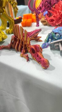 Small ichthyosaurus skeleton printed on 3D printer from molten plastic of pink orange color. Creative multicolored models printed on 3D printer. Concept 3D Printing. 3D Printing technology. Vertical